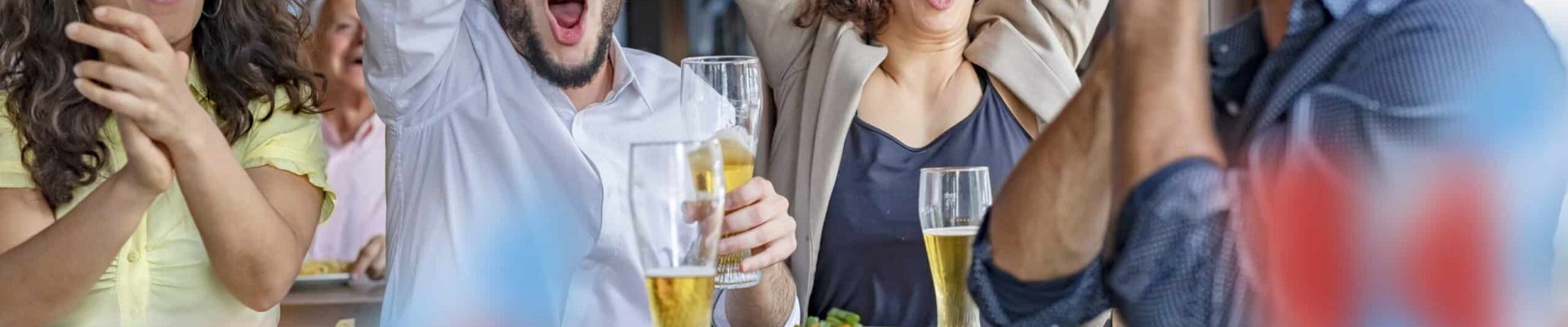 Group of soccer fans friends celebrating goal in pub